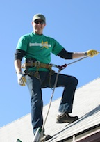 Brian Flechsig Owner Operator Denver Gutter Cleaning wearing a harness roped off on a roof