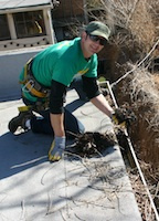 Denver Gutter Cleaning - Brian Flechsig scooping debris out of a clogged gutter